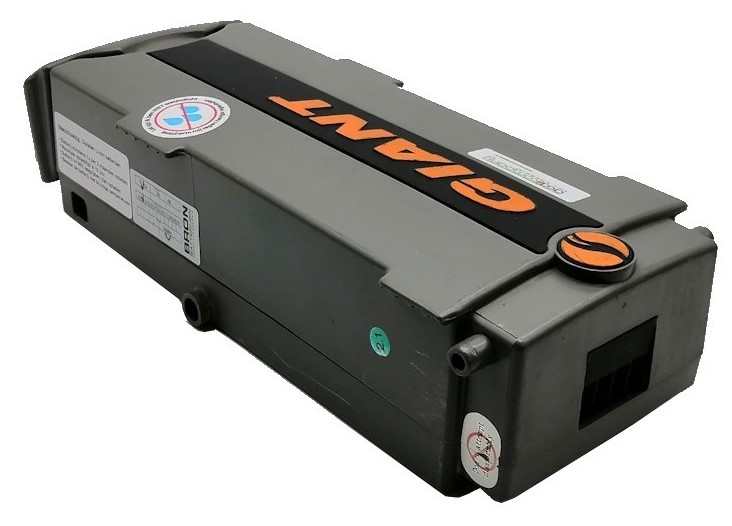 Gray industrial battery pack with orange branding, round orange cap, and various stickers on the surface.